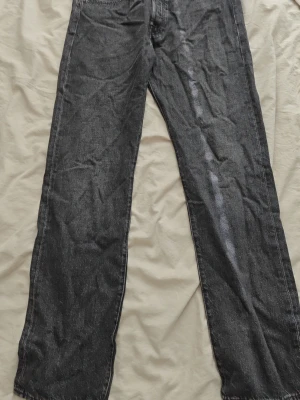 Levi's jeans - Säljer ett par svarta jeans med rak passform och klassisk femficksdesign. Jeansen har normal midja och är tillverkade i ett slitstarkt denimtyg. Perfekta för dig som gillar en enkel och tidlös stil.