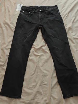 Only sons jeans - Säljer ett par svarta jeans med rak passform och klassisk femficksdesign. Jeansen har silverfärgade nitar och knapp, samt bälteshällor i midjan. Perfekta för dig som gillar en enkel och stilren look.