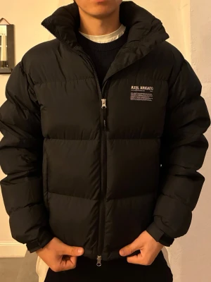 Svart pufferjacka från Axel Arigato - Säljer en snygg svart Observer pufferjacka från Axel Arigato i mycket bra skick. Storlek S. Modellen på bilden är dock 184 cm lång.                Använd under en vinter. Inköpt för 4800 :-. Säljer för 2000 :-. Skriv vid intresse eller om du har några frågor o funderingar!
