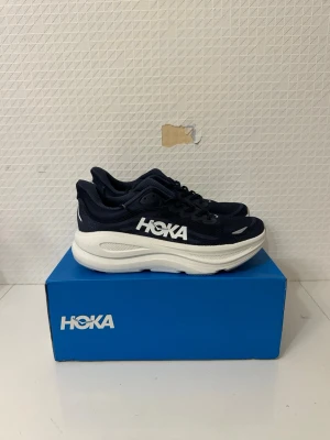 Hoka Bondi 9 Mörkblåa - Storlek 44 - Hoka Bondi 9 Mörkblåa - Storlek 44  Skorna är i nyskick och mycket sparsamt använda. Fräscha och välskötta, utan tydliga märken eller slitage.  Köpta på Stadium 2299:-