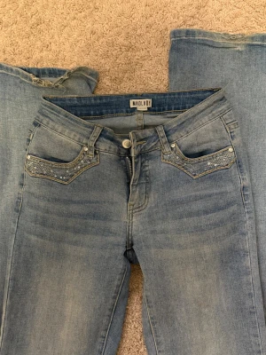 Lågmidjade jeans med snygga bakfickor - Säljer dessa lågmidjade jeans ifrån madlady med snygga bakfickor. De är lite slitna nedantill samt ett litet hål, men annars i bra skick.