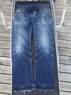 Levis 505(1967) vintage clothing – Cone Mills Selvedge Denim – W32 L32 - Säljer ett par Levi’s 505 (1967) Vintage Clothing (LVC) tillverkade i den eftertraktade Cone Mills White Oak-selvedgen, känd för sin höga kvalitet och fantastiska patina. Jeansen har fått en naturlig och snygg inbärning med fina fades och honeycombs, utan överdrivet slitage. 	•	Storlek: W32 L32 	•	Äkta Levi’s Vintage Clothing (LVC) 	•	Tillverkade i Cone Mills White Oak selvedge denim 	•	Klassisk vintagepassform 	•	Naturligt inburna med fin patina 	•	Nederkanten är rå/sliten efter användning.