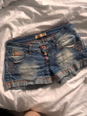 Lågmidjade vintage yk2 shorts  - Super söta lågmidjade vintage yk2 jeans shorts med orange och rosa detaljer! Fint skick och står ingen storlek men som xs/34 💓