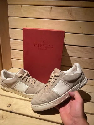 Rosa valentino flycrews - Stilrena sneakers från Valentino i beige mocka och vitt läder. Skorna har klassisk låg profil, rund tå och beige snörning. Perfekta för dig som gillar exklusiv och tidlös design med en lyxig känsla.