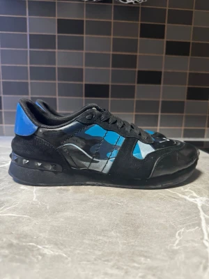 Valentino rockrunners blåa camouflage  - Säljer ett par sjukt snygga Valentino sneakers i blått camouflagemönster. Klassiska Rockstud-detaljer på hälen. Perfekt till dig som gillar stilen ”grisch”😍🤝