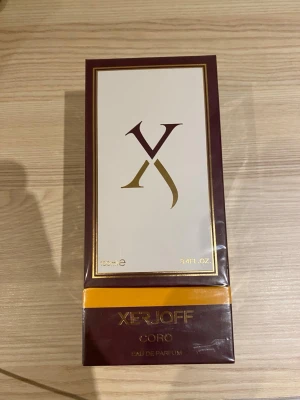 Xerjoff Coro Eau de Parfum 100ml - Lyxig parfym från Xerjoff, Coro Eau de Parfum, i en elegant mörkröd och guldvit förpackning. Flaskan rymmer 100 ml och har exklusiv italiensk design med gulddetaljer. Perfekt för dig som vill ha en unik och sofistikerad doftupplevelse.