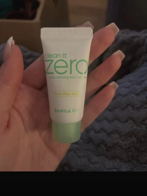 Clean It Zero pore cleanser mini - Clean It Zero pore clarifying foam cleanser från Banila Co i en liten tub på 15 ml. Tuben är vit med gröna detaljer och har en grön skruvkork. Innehåller pore-peel acid och passar för rengöring av ansiktet.