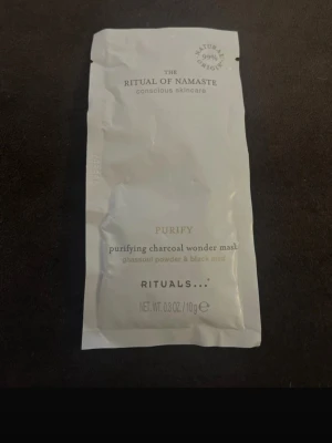 Rituals Purifying Charcoal Wonder Mask - En ansiktsmask från Rituals, The Ritual of Namaste-serien. Masken är i en vit engångsförpackning och innehåller ghassoulpulver och svart lera för djuprengöring. Perfekt för dig som vill ha en fräsch och ren känsla i huden.