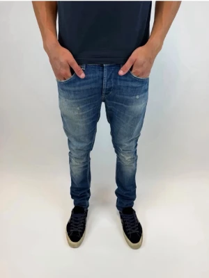 Blå slim fit jeans med slitningar - Snygga blå jeans med lätt slitna detaljer och tvättad look. Jeansen har klassisk femficksdesign och normal midja. Perfekta för en avslappnad och trendig stil.