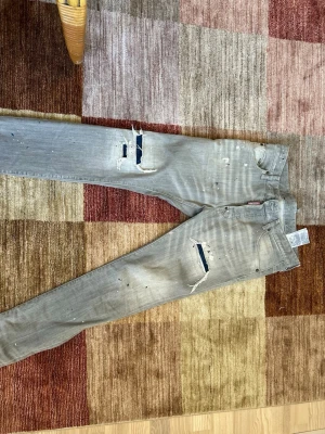 Limited dsquared jeans - Säljer ett par limiterad dsquared jeans med blåa detaljer som jag använt 2-3 gnr max. Byxorna kommer med extra knappar samt en hängare från märket.
