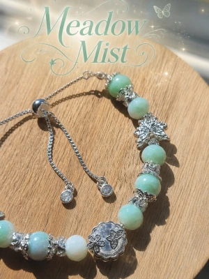 Meadow🌿Mist Armband - Magiskt armband med ljusmintgröna pärlor, dekorerat med silverfärgade detaljer och fjärilar. Armbandet har justerbar kedja och gnistrande små hängen. Perfekt för dig som gillar naturinspirerade accessoarer.