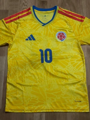 Colombia Home Jersey 2026 World Cup JAMES #10 – Size S - Represent Colombia in style with the iconic 2026 Home Jersey featuring legendary playmaker James Rodríguez #10. This jersey is a must have!  * 🇨🇴 Colombia 2026 Home Jersey * ⭐ James Rodríguez #10 * 📏 Size: Small (S) * ✅ Brand New without tags * 💨 Breathable, lightweight material * 👕 Comfortable athletic fit * ⚽ Perfect for football fans, collectors, and casual wear