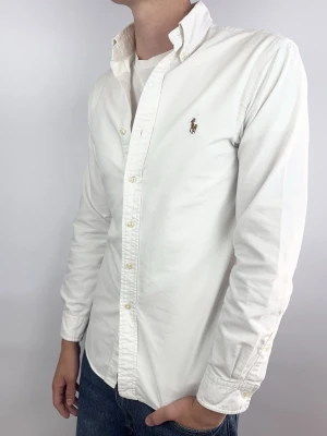 Ralph Lauren skjorta vit slimfit - Vit slimfit Ralph Lauren skjorta Märke: Ralph Lauren Storlek: S Passform: Slimfit Färg: Vit Skick: Mycket bra, en fläck som är typ ”onsynlig” ovanför hästmärket.