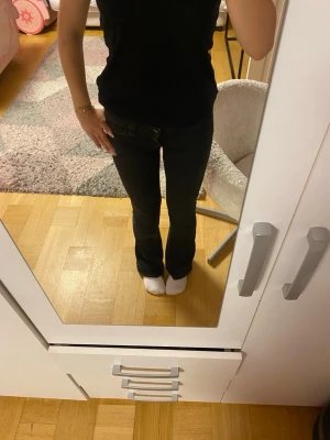 Svarta bootcut Cheap Monday  jeans - Säljer ett par svarta bootcut jeans med klassisk femficksmodell med låg midja. Jeansen har utsvängda ben och är tillverkade i ett stretchigt material som sitter snyggt. Perfekta för dig som gillar en tidlös och trendig look. Säljer på grund av att de är stora på mig. De är min 5 användning och jag har tvättat dem efter varje gång och färgen har tappats lite vid innerbenen. 