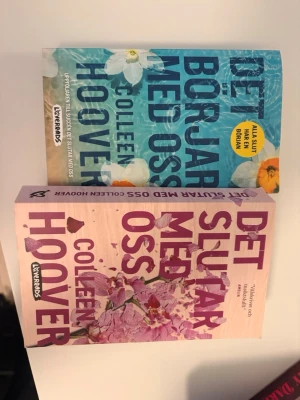 Det börjar & slutar med oss - Colleen Hoover - Två populära pocketböcker av Colleen Hoover: 'Det börjar med oss' med blått omslag och blommor, samt 'Det slutar med oss' med rosa omslag och blommor. Perfekta för dig som gillar romantik och gripande berättelser. Båda böckerna är på svenska och utgivna av Lovereads. Både har lästs en gång