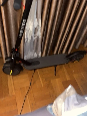 Svart elscooter utan ladd går 30km - Säljer en svart elscooter med laddare. Scootern har en stilren design med bred fotplatta och handtag med bra grepp. Perfekt för att ta sig runt i stan på ett smidigt sätt. Laddningskabel medföljer.