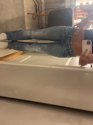 Blåa diesel jeans med slitningar - Snygga blå diesel jeans med slitna detaljer och lätt tvättad look. Jeansen har låg midja, klassiska fem fickor och dragkedja med knapp. Perfekta för en avslappnad och trendig stil.