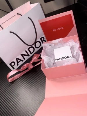 Pandora silverring med pärldetalj - Säljer en stilren silverring från Pandora med en elegant pärldetalj. Ringen levereras i original ask och presentförpackning, perfekt som gåva. Designen är klassisk och tidlös med en feminin touch.
