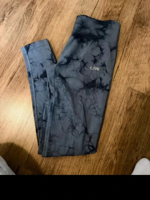 Gråmönstrade leggings från ICANIWILL - Snygga grå leggings från ICANIWILL med marmorerat mönster och hög midja. Stretchigt material som sitter skönt och följer kroppen. Perfekta för träning eller chill. Logga på låret och långa ben.