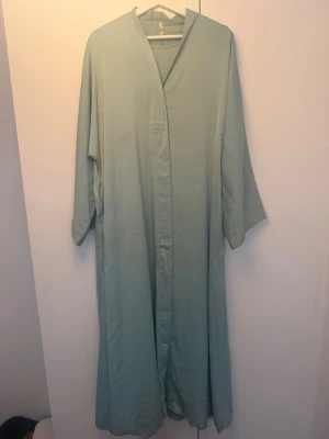Turkos abaya med underklänning - Jätte fin turkos abaya i silkes-likt material. Tidigare köpt hos ett abaya företag på Instagram. Skriv för bilder med den på! Bra skick men har lite märken längst ner i kanten då den släpade för mig som är 160