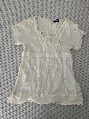 Krämvit blus från Soaked in Luxury - Söt krämvit blus från Soaked in Luxury med spetsdetaljer och v-ringning. Säljer då den var för stor för mig☺️💞står storlek S men skulle mer säga m