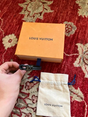 Louis Vuitton armband  - Säljer ett sjukt snyggt och unikt Louis Vuitton armband för endast 2599 men pris kan självklart diskuteras vid snabb affär, ny pris 4000kr, dustbag medföljer armbandet jag monogram på ena sidan och läder på andra 