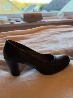 Tamari’s ❣️ klack skor - Säljer ett par svarta pumps med rundad tå och stabil, bred klack. Skorna har en enkel och tidlös design i slätt material som ger en stilren look. Perfekta för dig som vill ha ett par klassiska klackar till garderoben.
