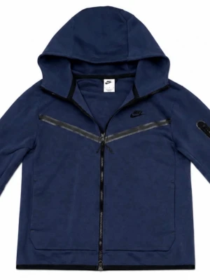 Nike tech - Snygg mörkblå hoodie från Nike med hel dragkedja framtill och två stora fickor. Hoodien har svarta detaljer, en huva och en diskret Nike-logga på bröstet. Materialet är mjukt och bekvämt, perfekt för en avslappnad stil.