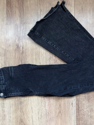 Gråa jeans med rå kant - Säljer ett par jeans med trendig rå kant nertill. Jeansen har rak passform och klassisk femficksdesign. Materialet är denim med lätt stretch för extra komfort. Perfekta för dig som gillar en avslappnad men ändå stilren look.
