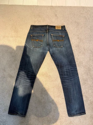  Nudie Jeans dry selvage  - Tja, jag säljer ett par as feta nudie dry selvage jeans! I mycket bra skick, med snygga fades och  lagningar! Storlek W33 L32, Modell: Fearless Freddie,  som inte sälj längre vilket gör de rare! Kom även med prisförslag!