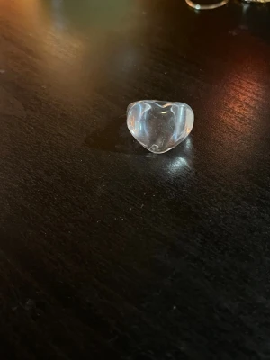 Ringar i silver, guld och akryl - Säljer ett set med  ringar: en transparent hjärtformad ring i akryl och sju silvriga/guldiga. Perfekta för att mixa och matcha till din egen stil. 15kr styck, kan komma överens om annat pris om man vill ha flera st