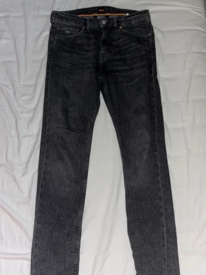 Svarta jeans från BOSS - Säljer ett par svarta jeans BOSS i riktigt bra skick. Byxorna har en go strech i sig och sitter riktigt bra. Storleken är W30 L32