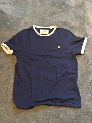 Lyle&Scott T-shirt  - Denna har knappast använts och är i toppskick. Det är en riktigt fin mörkblå lyle & scott t-shirt som är i storleken S.