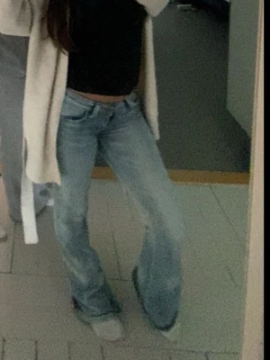 Weekday Ljusblå bootcut jeans - Säljer ett par ljusblå bootcut jeans med låg midja och klassisk femficksmodell. Jeansen har en avslappnad passform och är tillverkade i denim med lätt tvättad look. Perfekta för dig som gillar retrostil och vill ha ett par riktigt snygga jeans med bredare ben. Storleken är 26/30 så antigen XS, XXS eller S men jag har som S i beskrivningen men vet inte vilket storlek det är egentligen!