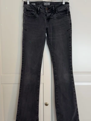 Svarta bootcut jeans med fickor - Snygga svarta bootcut jeans från LTB med klassiska fem fickor och låg midja. Jeansen har en lätt tvättad look och raka ben som går ut något nedtill. Perfekta för dig som gillar en tidlös och avslappnad stil. 📍STORLEKEN är w25 och L32📍