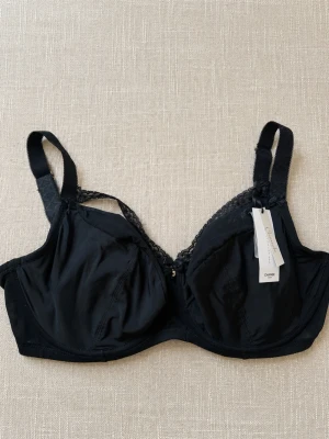 Svart bygel-bh med spetsdetaljer - 🖤 Elegant BH från CHANGE Lingerie, modell Ibi, i storlek 75H. Snygg feminin modell med fina detaljer och bra stöd för större byst. 🔖 Storlek: 75H ✨ Skick: Helt ny och oanvänd. 🏷️ Nypris: 899 kr  Perfekt till dig som redan känner till CHANGE:s passform och söker modellen Ibi i 75H. 