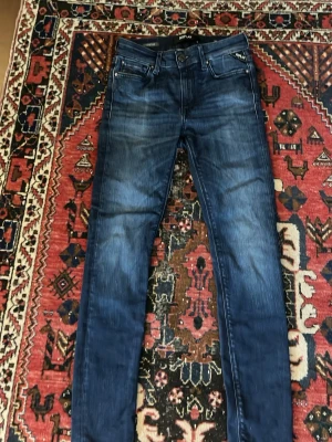 Mörkblå skinny jeans från Replay hyperflex w26 l28 - Snygga mörkblå skinny jeans från Replay med  tvättade detaljer. Klassisk femficksmodell med dragkedja och knapp. Jeansen är tillverkade i stretchigt material för extra komfort och har Replay-logga på fickan.