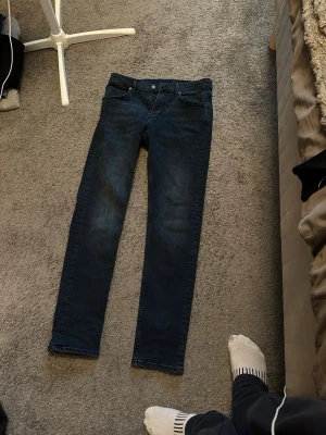 J.Lindeberg jeans  - Säljer ett par mörkblå jeans med rak passform och klassisk femficksdesign. Jeansen har normal midja och subtila slitningar för en avslappnad look. Perfekta till sneakers eller boots och passar till det mesta i garderoben. Byxorna är knappast använda och har en lite mer skinny passform
