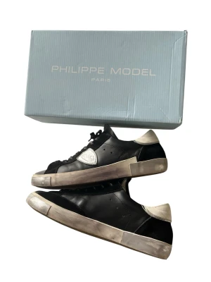 Svårhittade Philippe Model  - Ett par svårhittade Philippe Model Paris sneakers i en exklusiv och unik design. Den svarta färgen tillsammans med de slitna vintage-inspirerade detaljerna ger skorna ett väldigt speciellt uttryck som sticker ut. En mer sällsynt modell som är svår att hitta, perfekt för dig som vill ha ett par sneakers som inte alla andra har.