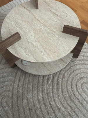 Nytt runt soffbord – oöppnat - Säljer ett helt nytt runt soffbord i modern och stilren design.  Bordet är helt oöppnat och ligger kvar i originalkartongen. Bilderna visar samma modell som vi har hemma.  Ljus sten/travertin-look med trädetaljer och en praktisk hylla undertill. Passar väldigt fint i ett modernt eller minimalistiskt hem.  Pris: 1 900 kr  Finns för avhämtning & kan även skickas. Kan diskutera pris vid snabb och smidig affär.