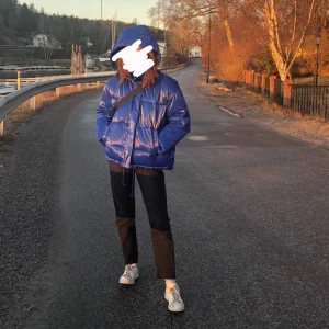 Blank duvjacka i blått - Mycket tredig blank duvnjacka i blått. Varm och funkar perfekt nu till vintern. Mycket bra skick, saknar dock snöre i luvan. Högst bud