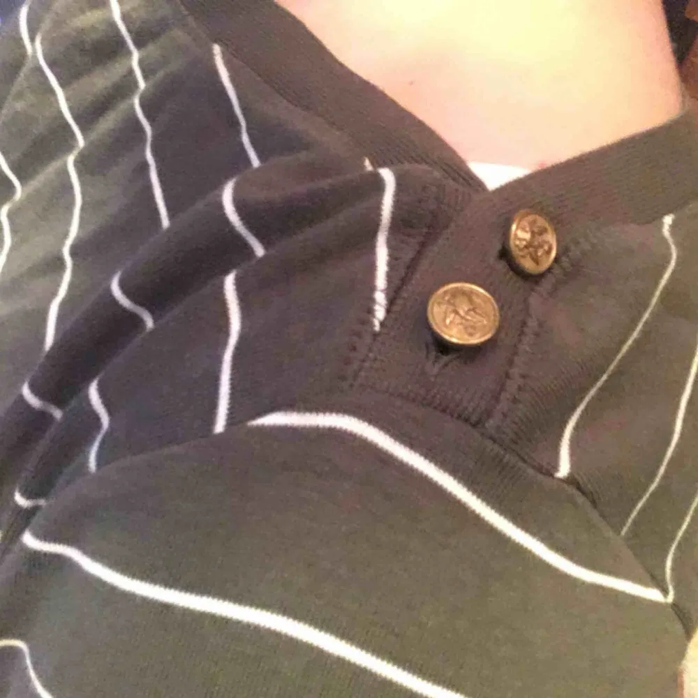 Långärmad randig tröja från Ralph Lauren med knappar på vardera sida ringningen. Toppar.
