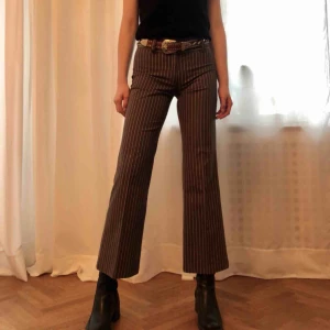  - Utsvängd byxa i brunt med smala beiga ränder. Material: bomullsblandning. Stlk. S, normallängd. Köparen står för frakt, kan även mötas upp!