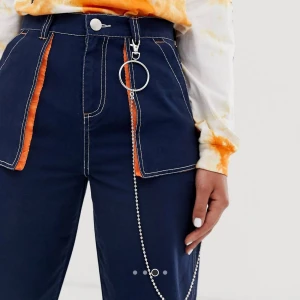  - Coola marinblåa jeans med kontrastsömmar och neonoranget vid fickorna, följer även med en kedja som syns på bilderna. Oanvända! Kan mötas upp i växjö eller frakta. Har swish.  100% bomull  Strl 38, från asos.com  Fraktkostnad tillkommer. 