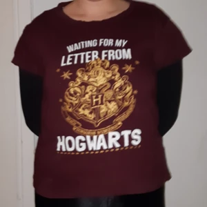  - Hp tisha! 🤓 mörkröd med Hogwarts sköld som tryck. 
