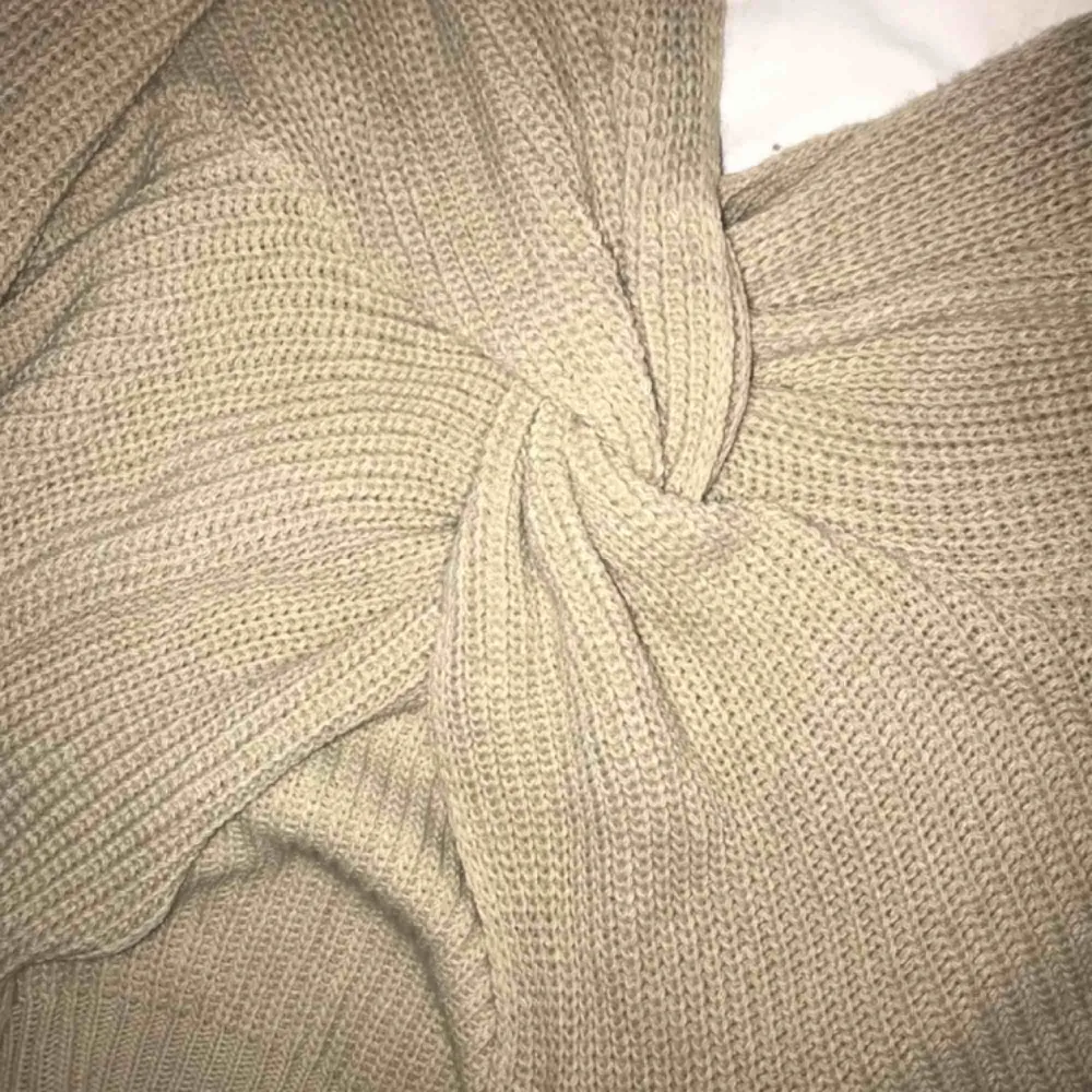 Beige stickad tröja med knytning som man kan ha både bak och fram. Passar nog de flesta storlekar. Kommer tyvärr aldrig till användning. Frakt kostar 40kr 🥰. Stickat.