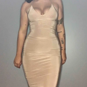  - Beige bodycon klänning i slinky material, når till knäna på mig som är 170. Mycket bra skick.
