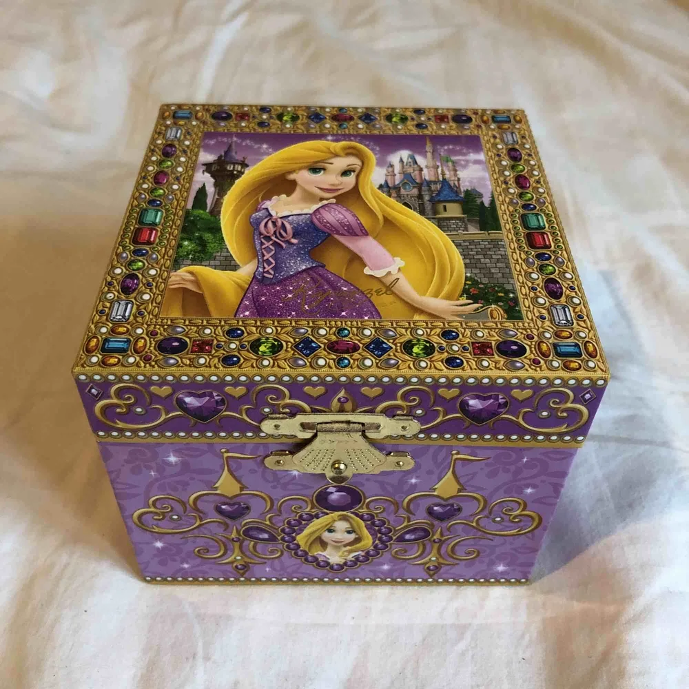 Ett litet skrin med Rapunzel som spelar en låt när man öppnar (I see the light). Utsidan är 8,5x10,5x10,5 cm och insidan är 5x9,7x7 cm HxBxD. Accessoarer.