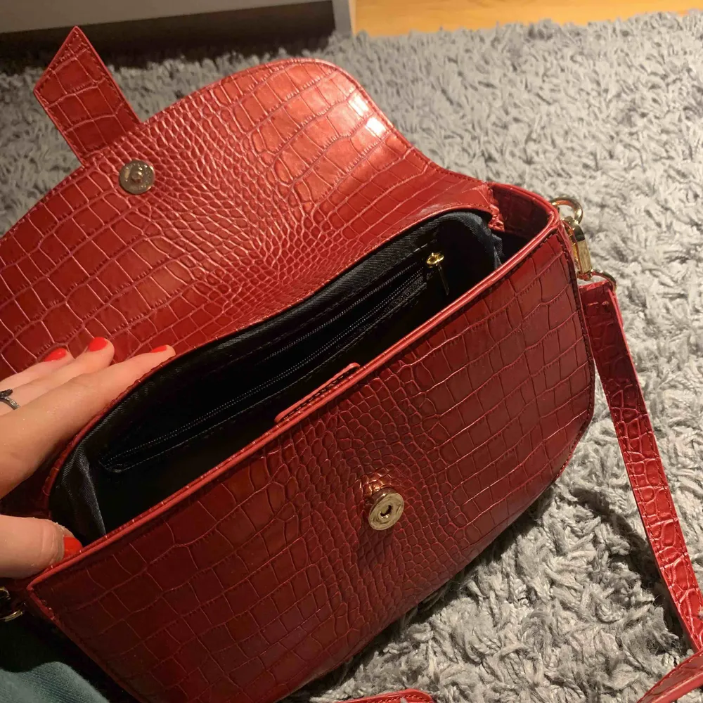 En väldigt fin och rymlig röd väska från NAKD som jag köpte för ett tag sen men har inte fått anständig av den tyvärr! Den är i helt nytt skick. Det tillkommer ett långt och ett kort axelband! Priset är inräknad med frakt:). Väskor.