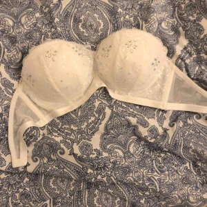  - Vit bandeau med spets och fina detaljer. Aldrig använd. Storlek 75 C med pushup. 